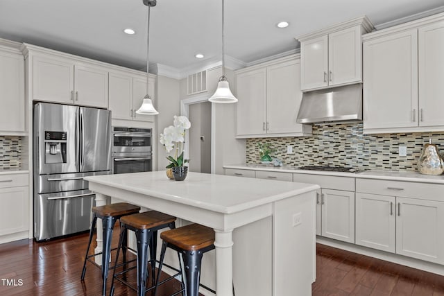 kitchen featuring under cabinet range hood, stainless steel appliances, visible vents, and light countertops