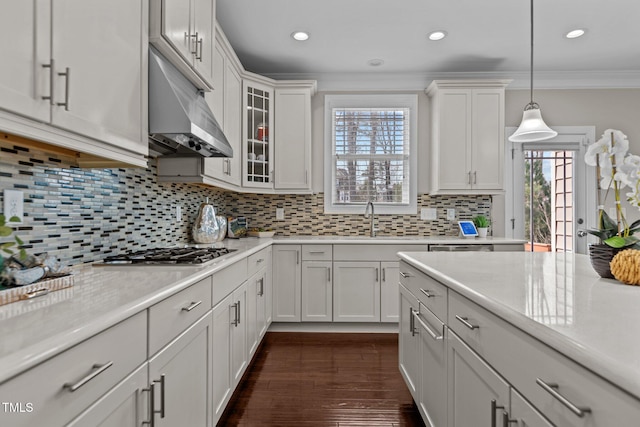 kitchen featuring dark wood finished floors, a sink, light countertops, stainless steel gas stovetop, and crown molding