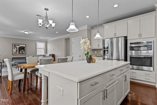 kitchen featuring decorative light fixtures, ornamental molding, decorative backsplash, dark wood-style floors, and stainless steel appliances