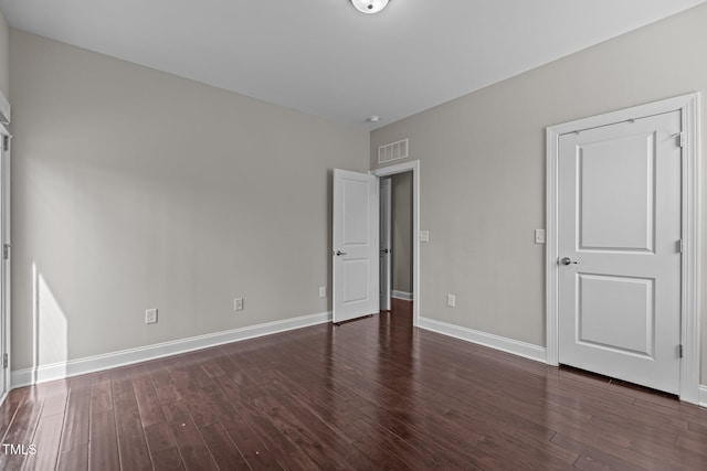 unfurnished bedroom featuring wood finished floors, visible vents, and baseboards