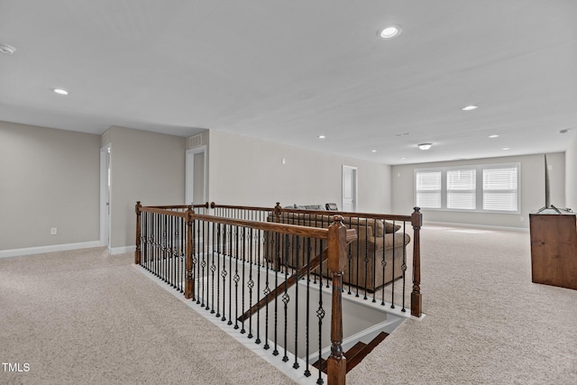 hallway featuring carpet flooring, an upstairs landing, recessed lighting, and baseboards