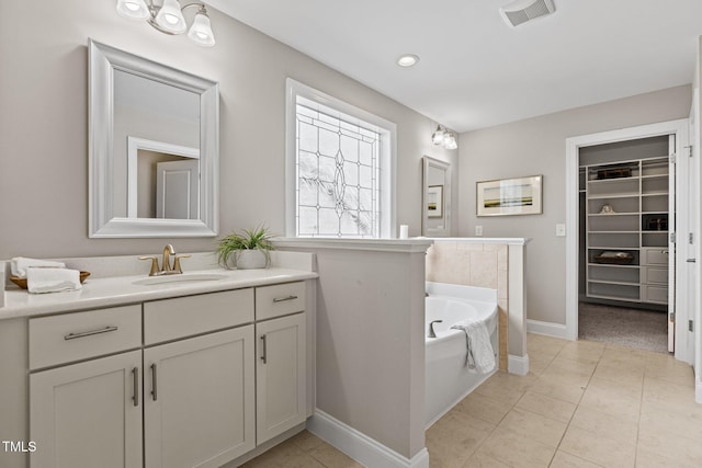 bathroom with vanity, visible vents, tile patterned flooring, a spacious closet, and a bath