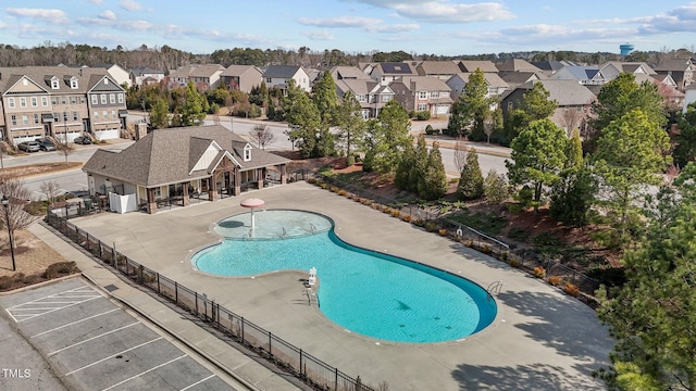 pool with a residential view, a patio, and fence