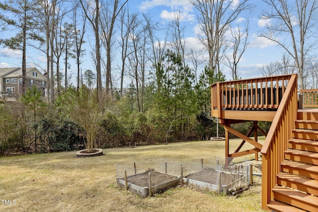 view of yard featuring stairway, a vegetable garden, and a deck