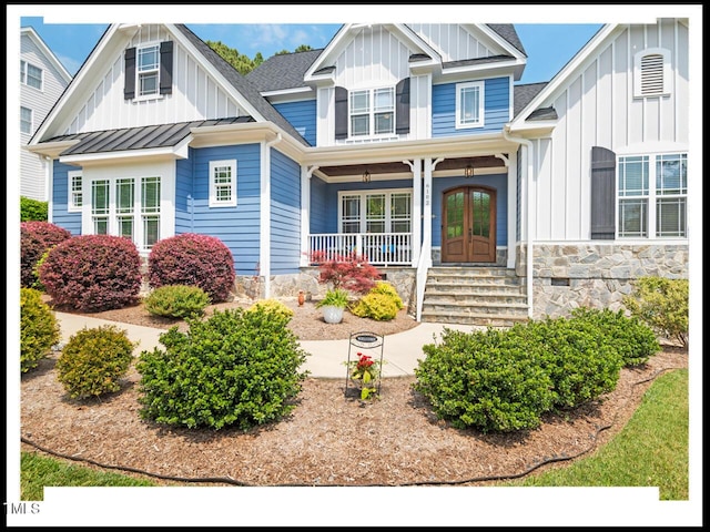 view of front of house featuring a standing seam roof, a porch, french doors, board and batten siding, and metal roof