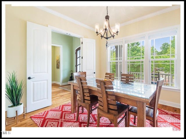 dining room with a notable chandelier, baseboards, light wood-type flooring, and ornamental molding