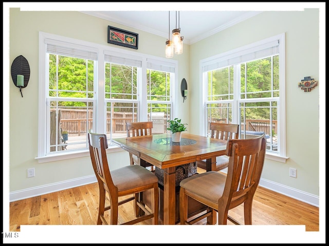 dining space with an inviting chandelier, light wood-type flooring, baseboards, and ornamental molding