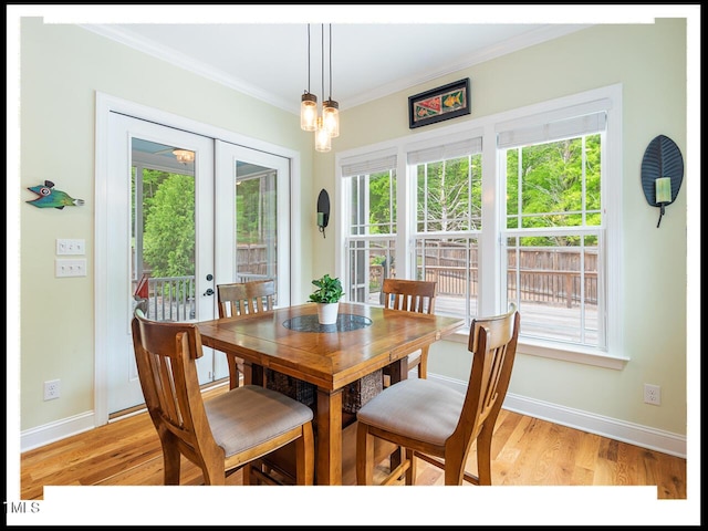 dining space featuring french doors, baseboards, light wood-style floors, and ornamental molding