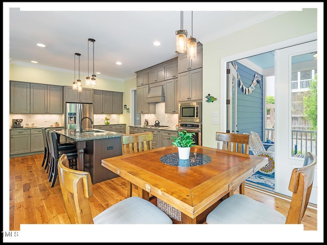 dining area with light wood finished floors, recessed lighting, and ornamental molding