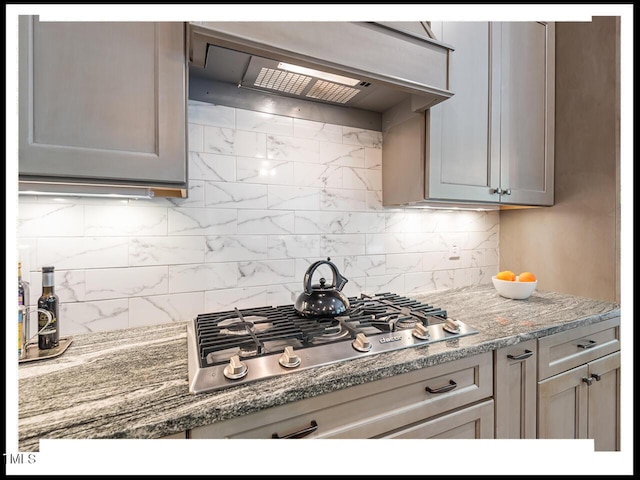 kitchen with decorative backsplash, stainless steel gas stovetop, and under cabinet range hood