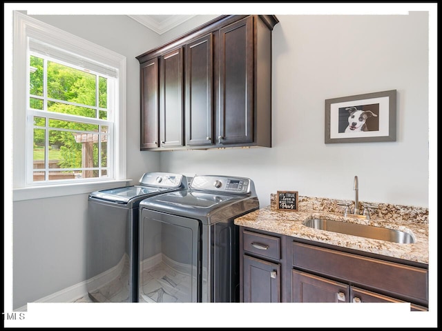 washroom with a sink, cabinet space, crown molding, and washing machine and clothes dryer