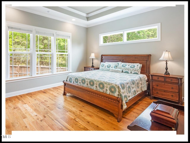 bedroom with multiple windows, crown molding, baseboards, and wood finished floors