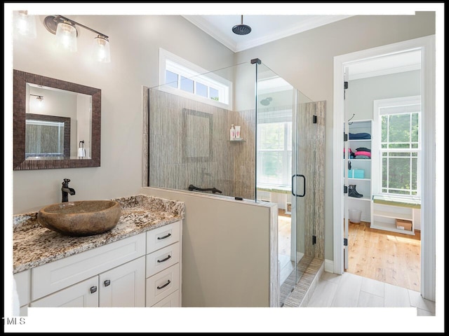 bathroom featuring a stall shower, vanity, and crown molding