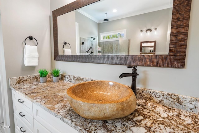 full bathroom featuring vanity, crown molding, and a stall shower