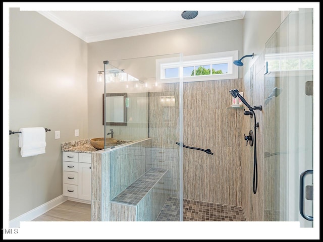 full bath featuring baseboards, vanity, ornamental molding, and a shower stall