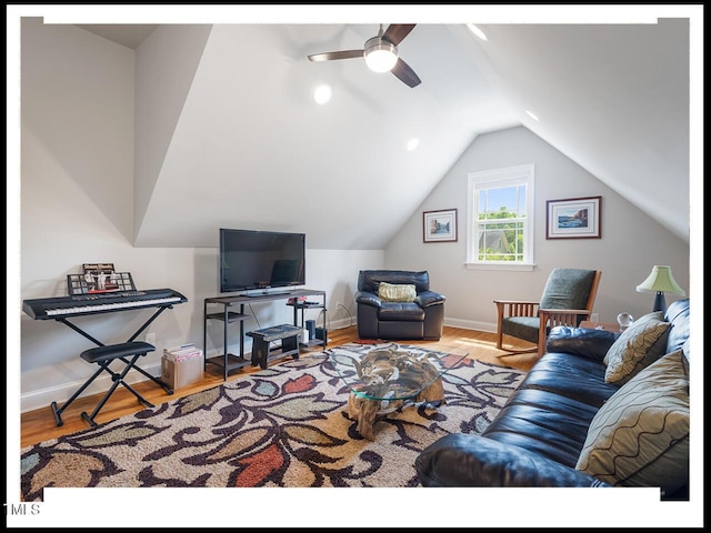 living room with vaulted ceiling, baseboards, and wood finished floors