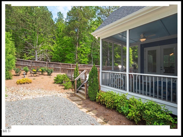 view of yard with fence, a sunroom, and ceiling fan