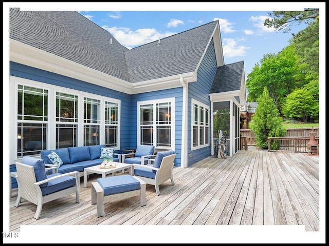 wooden deck featuring an outdoor living space with a fire pit