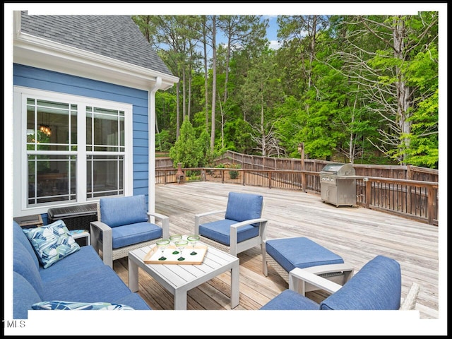 deck featuring an outdoor living space, fence, and a grill