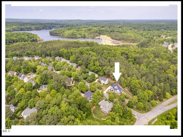 birds eye view of property featuring a view of trees and a water view