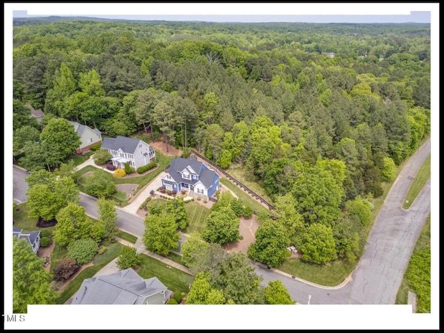 bird's eye view with a wooded view