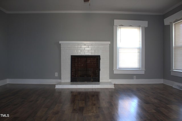 unfurnished living room with a brick fireplace, baseboards, ornamental molding, and dark wood finished floors