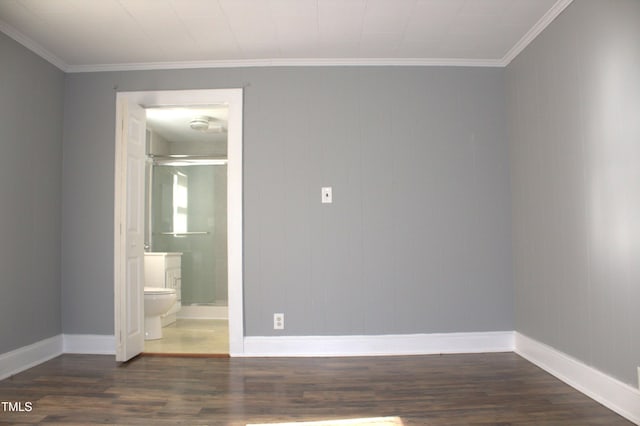 empty room featuring ornamental molding, dark wood-type flooring, and baseboards