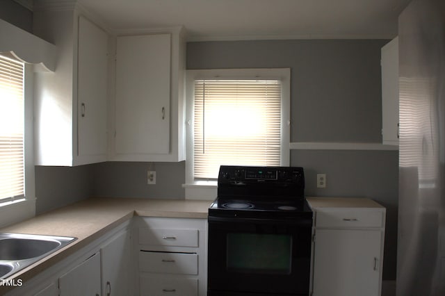 kitchen with light countertops, white cabinets, black electric range oven, and a sink