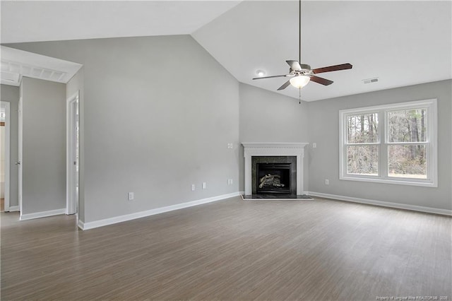 unfurnished living room featuring a premium fireplace, wood finished floors, visible vents, baseboards, and a ceiling fan