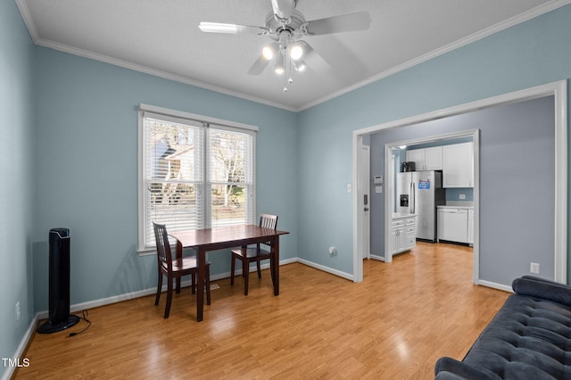 dining space featuring baseboards, ceiling fan, crown molding, and light wood finished floors