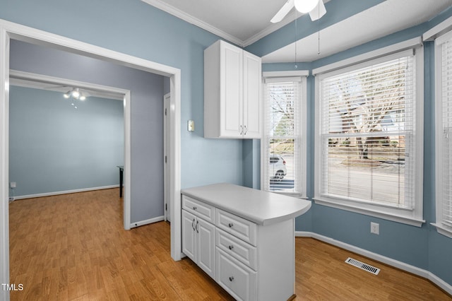 kitchen with visible vents, light wood-style floors, ceiling fan, and white cabinets