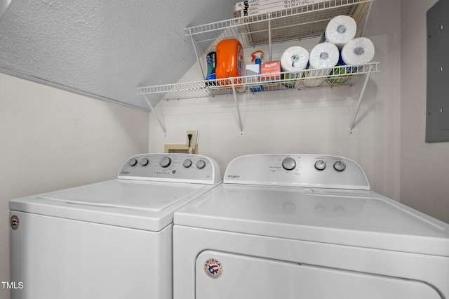 laundry room with a textured ceiling, laundry area, electric panel, and washing machine and clothes dryer