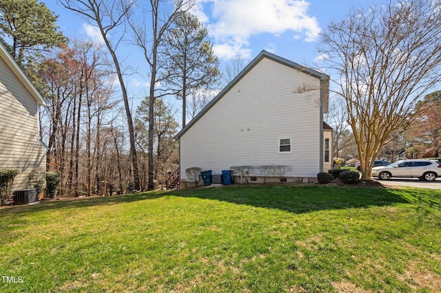 view of property exterior with a lawn and central AC