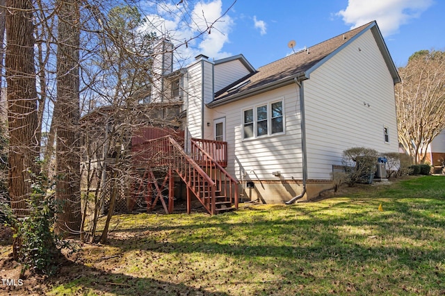 rear view of house featuring stairway, roof with shingles, a yard, a chimney, and a deck