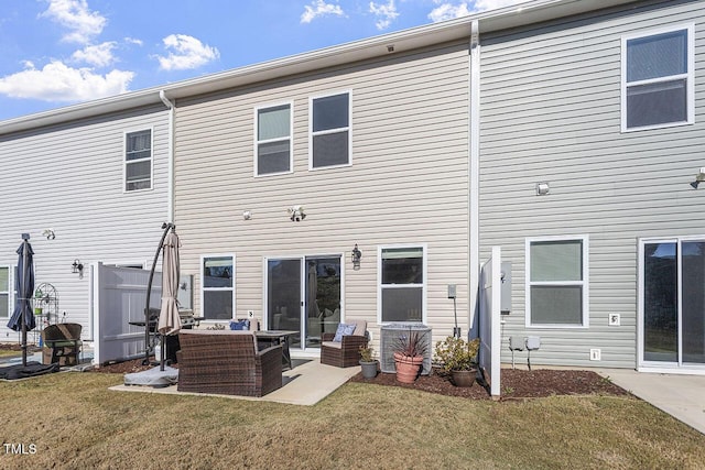 back of house with an outdoor living space, a yard, and a patio area