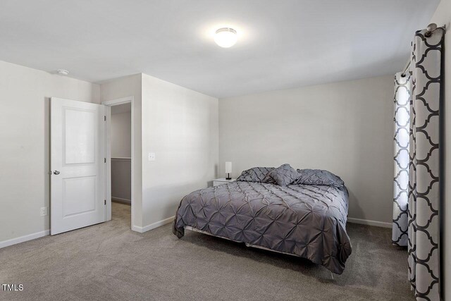 carpeted bedroom featuring baseboards