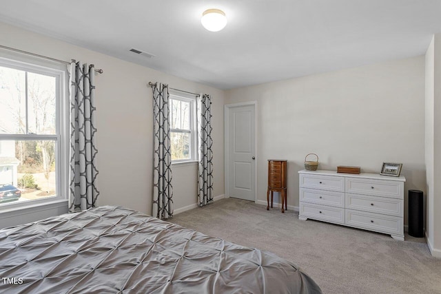 unfurnished bedroom featuring visible vents, light carpet, and baseboards