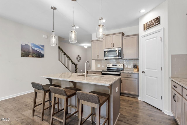 kitchen featuring tasteful backsplash, dark wood-style flooring, appliances with stainless steel finishes, and a sink