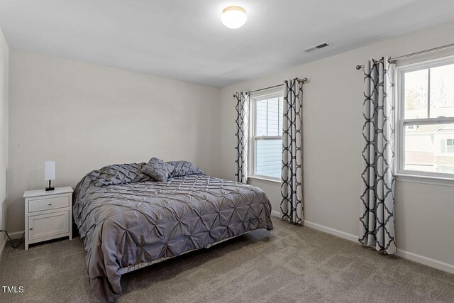 carpeted bedroom with visible vents and baseboards