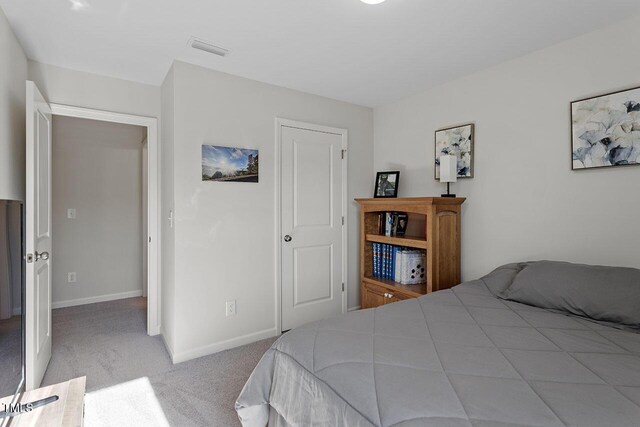 carpeted bedroom with visible vents and baseboards