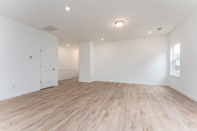 empty room with light wood-style flooring, visible vents, baseboards, and recessed lighting