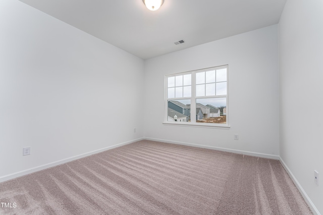 unfurnished room featuring carpet flooring, visible vents, and baseboards