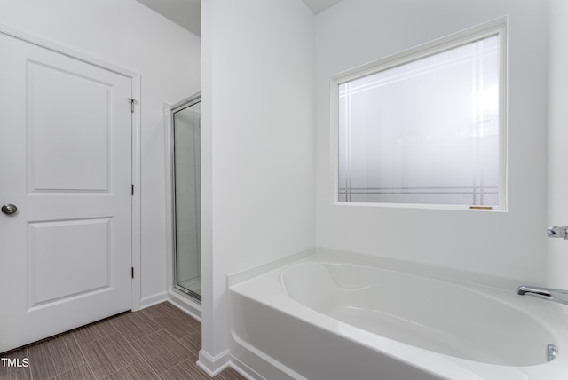 full bathroom featuring a shower stall and a bath