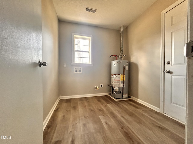 utility room featuring water heater and visible vents