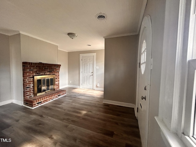 unfurnished living room with baseboards, visible vents, ornamental molding, wood finished floors, and a brick fireplace