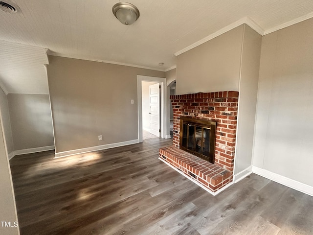 unfurnished living room featuring ornamental molding, a brick fireplace, visible vents, and wood finished floors