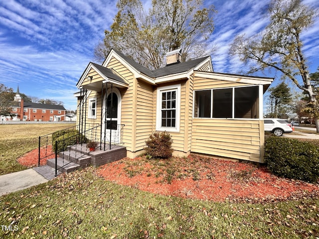 bungalow featuring a chimney and a front yard