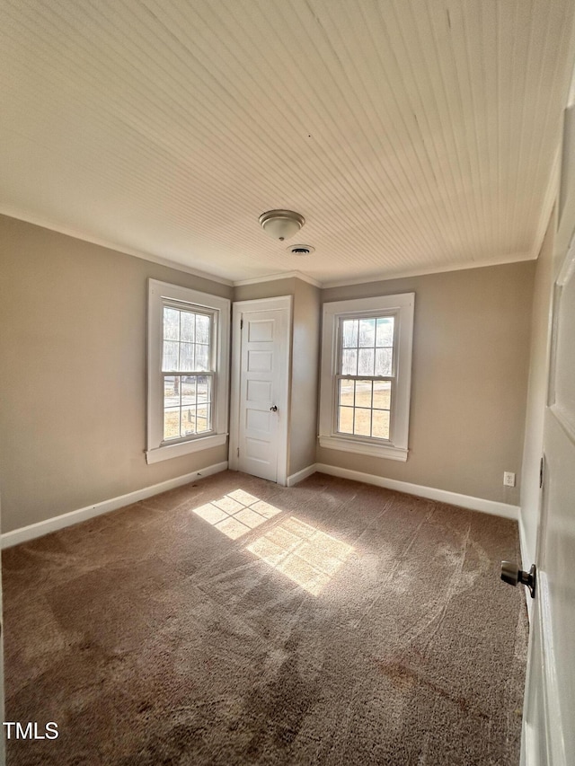 spare room with carpet floors, baseboards, and crown molding