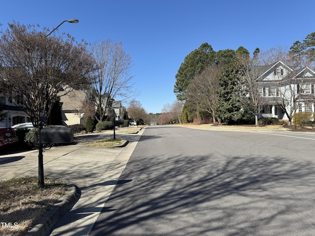 view of road with curbs, street lighting, and sidewalks