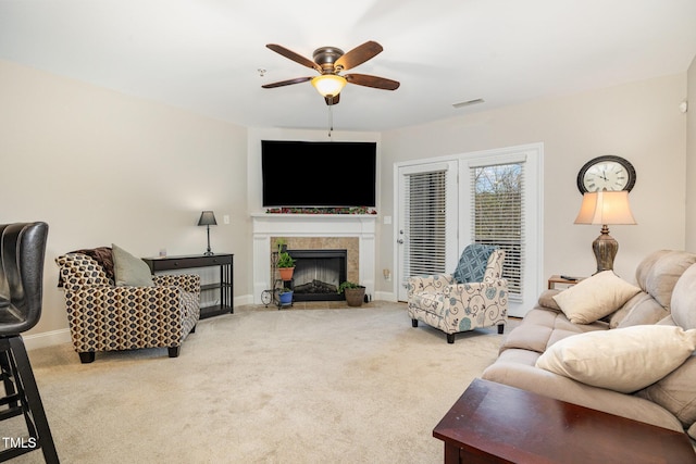 living room with a ceiling fan, baseboards, carpet, visible vents, and a tile fireplace